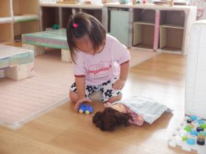 人形に布団をかけています。