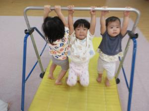 ３人で鉄棒にぶら下がっている