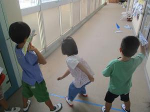 4歳児が5歳児と一緒に紙飛行機を楽しむ様子