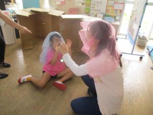 スカーフを頭に被せて遊ぶ先生と子ども