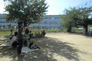 園庭で準備をして座る子どもたち