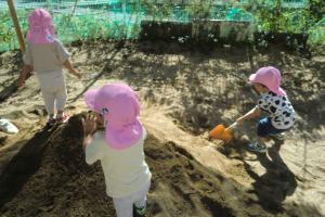 砂場で山を作る子ども