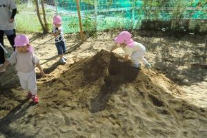 砂場の山に登る子ども