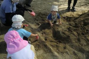 砂場で一緒に遊ぶ子ども