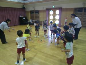 お手玉をフープの中をめがけて入れています