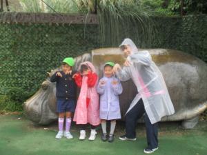 カバの銅像の前で写真を撮る子どもと先生