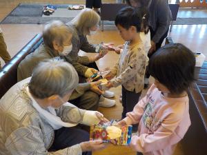 おばあちゃんたちにプレゼントを渡す子供たち
