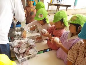 キッチンペーパーで芋を包む女の子たち