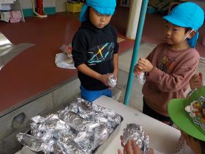 芋を包む５歳児の男の子