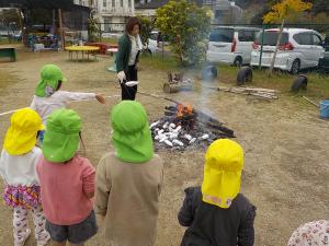 お芋を火の中に入れに行く姿