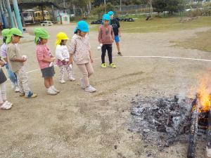 火の中に芋を入れている５歳児