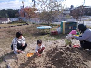 砂場でお家の方と遊んでいます