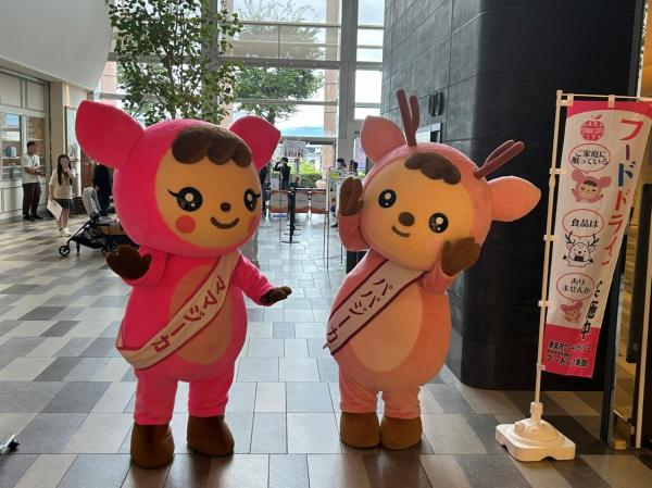 手を振るママジーカとパパジーカ