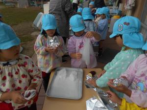 5歳児　いもを包んでいます