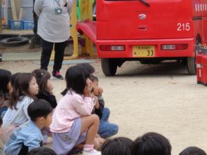 消防士の方のお話を聞く子ども