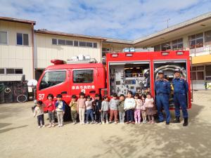 消防士の方と写真をとる子ども