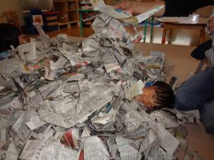 新聞紙の山に埋もれて遊んでいます
