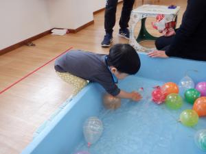 ヨーヨーの風船を手で触っています。