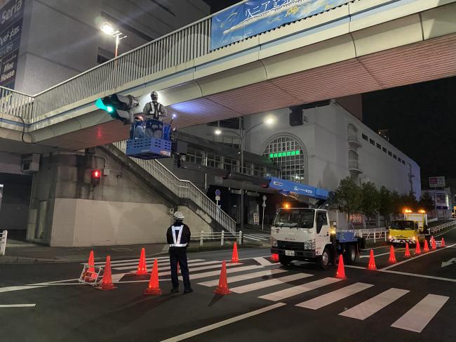 夜間、歩道橋周辺道路を交通規制し、点検作業をしている画像