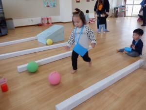 転がったボールを追いかけています。