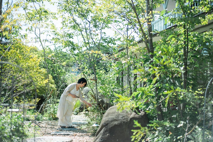 庭でハーブをつむ大西さん
