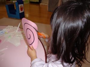 ハサミで渦巻きをきってタコあげのたこをつくっています