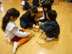 5歳児と1年生が高いタワーをつくっています