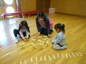 5歳児が友達や先生と花畑をつくっています