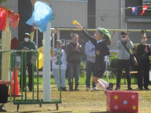 少し高いかごにボールを入れようとする園児