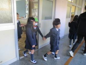1年生に手をつないでもらって移動する園児