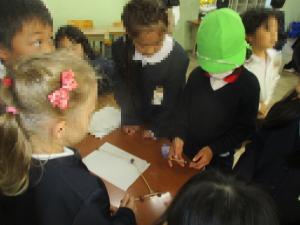 1年生にやじろべえを作ってもらう園児