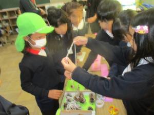 1年生にネックレスを作ってもらう園児