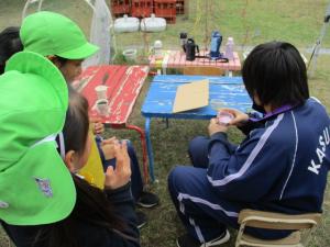 ままごと遊びを中学生と一緒にしている園児