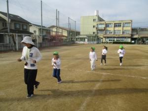 小学校の校庭を走る園児