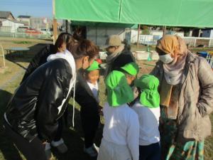 園庭でお家の人と気合を入れている園児