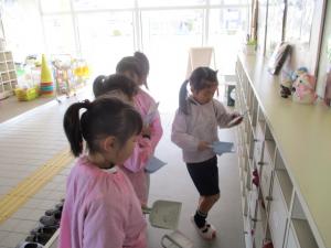 下駄箱を拭いている園児