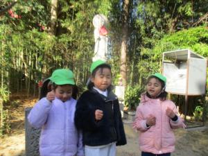 地蔵の前で同じ顔をして写真のポーズをとる園児