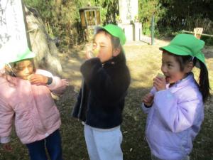 竹のコップに入った水を飲む園児