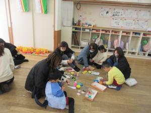 保護者の方に見守られながらひな人形をつくっています