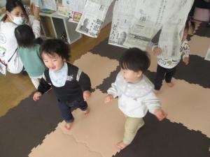 新聞紙で遊ぶ子ども達