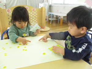 画用紙にシールを貼る子どもたち