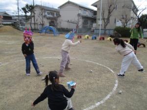 新聞紙で作った豆を投げている子ども達