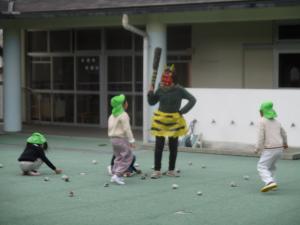 赤鬼に新聞紙の豆を投げる子ども達