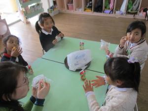 お菓子を食べる子どもと先生