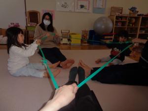 ゴムチューブをみんなで持って揺らして遊んでいます