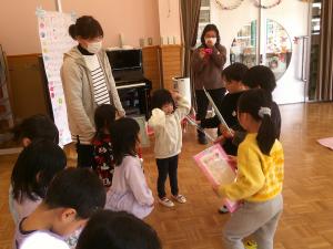 時間割表を渡す3歳児