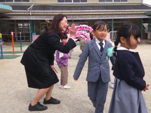 卒園式の戸外でアーチをくぐる様子