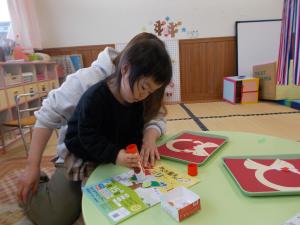 1月の製作「しめ縄」の材料にのりをつけています