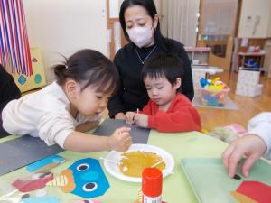 綿棒に絵の具を付けています