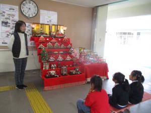 ひな壇の前で園長先生の話を聞く子ども達